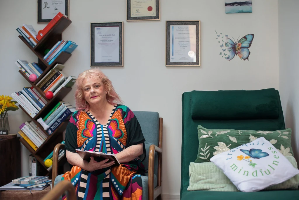 a person sitting in a chair holding a book